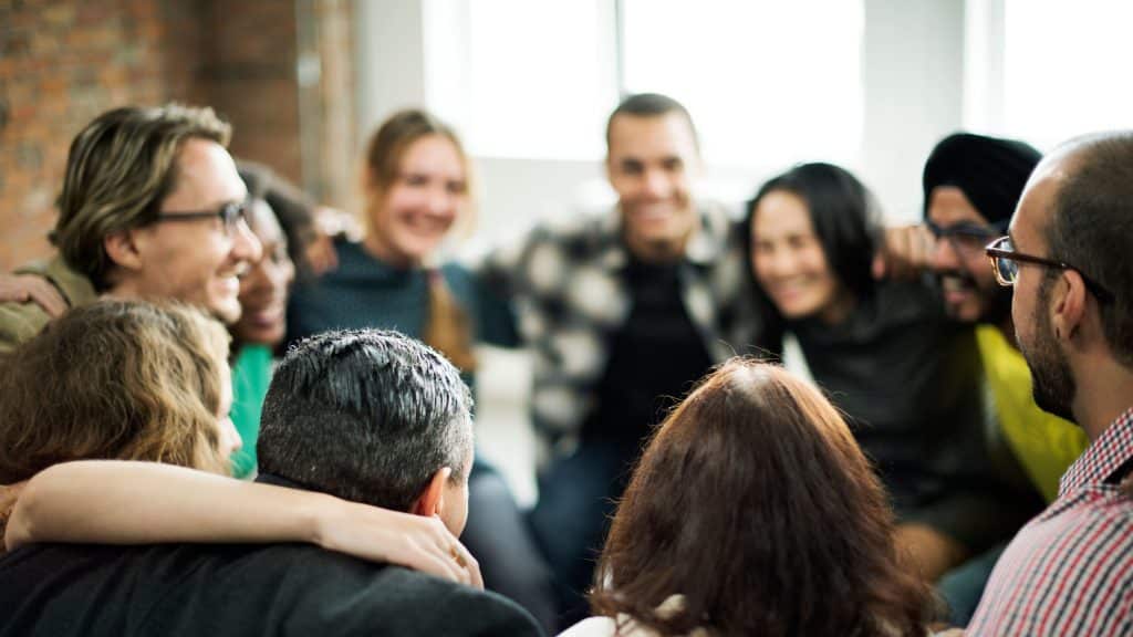 Le conflit d’entreprise : l’aspect positif : équipe heureuse, bras dans les bras